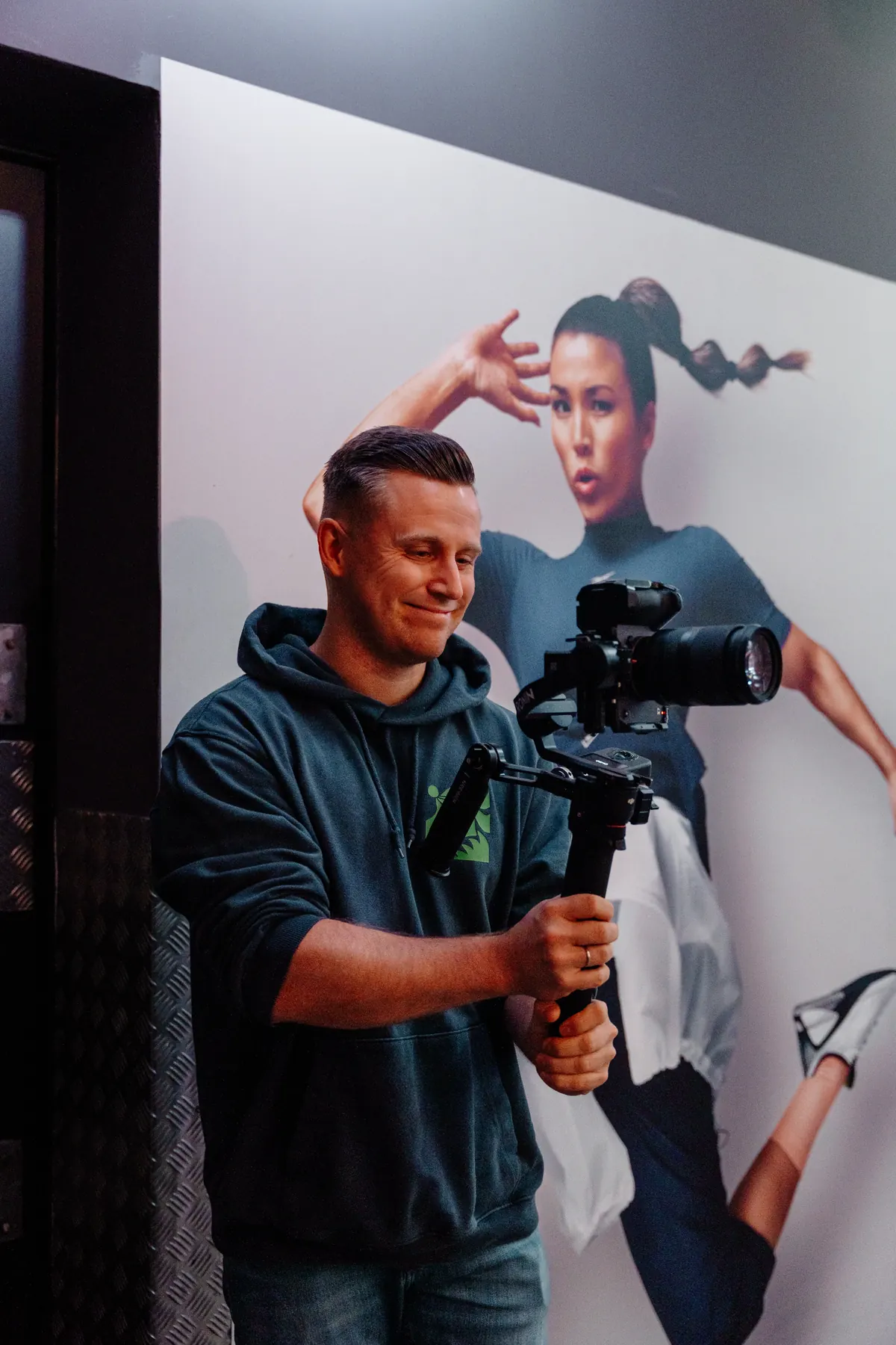 Toni filmt mit einer Kamera auf einem Gimbal im Fitnessstudio